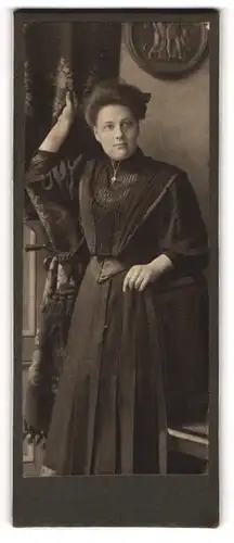 Fotografie Oscar Rothe, Hamburg, Portrait junge Dame in modischer Kleidung an Stuhl gelehnt
