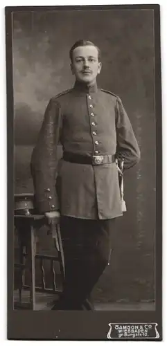 Fotografie Atelier Samson & Co., Wiesbaden, Soldat in Uniform mit Bajonett & Schlagband