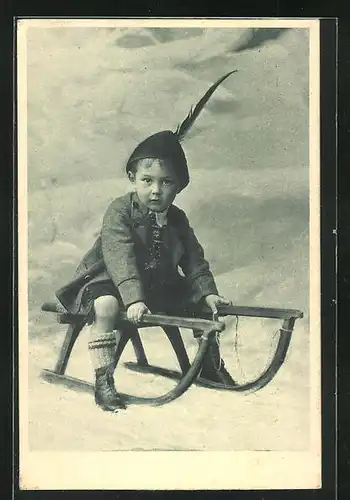 AK Kleiner Junge in Tracht auf einem Schlitten