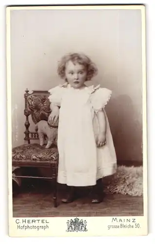 Fotografie C. Hertel, Mainz, Portrait niedliches Mädchen Johanna Koch im Nachthemd mit Plüschschaf auf dem Stuhl