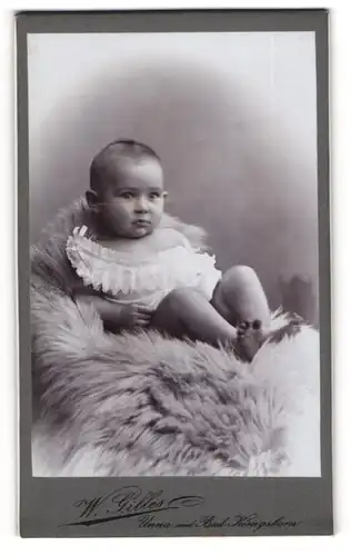 Fotografie W. Gilles, Unna, niedliches kleines Mädchen Hildegard Hengenbach auf einem Fell liegend, 1902