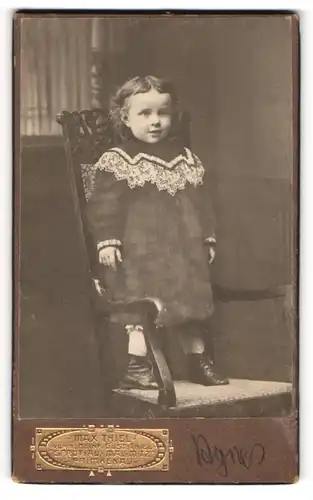 Fotografie Max Thiel, Sprottau, kleines Mädchen Agnes mit Kleid auf einem Stuhl stehend