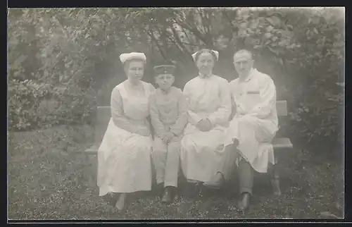 Foto-AK Krankenschwestern und ein Arzt des roten Kreuzes mit einem Kind