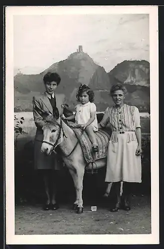 Foto-AK Kleines Mädchen auf Pony vor einer Studiokulisse