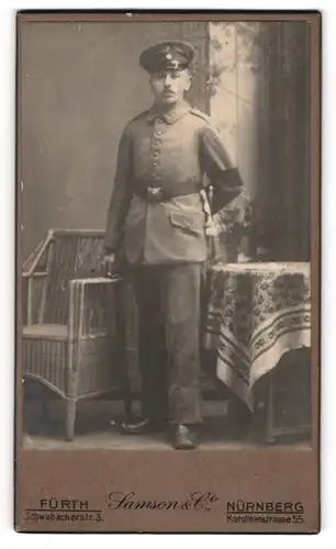 Fotografie Samson & Co., Fürth, Schwabacherstr. 3, Soldat in Feldgrau Uniform mit Trauerflor Armbinde und Bajonett