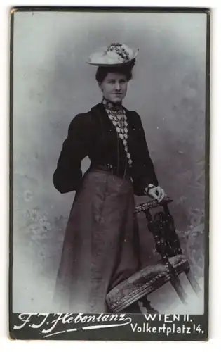 Fotografie F. J. Hebentanz, Wien, junge Frau Paula im dunklen Kleid mit Blumenhut