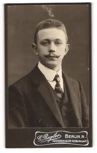 Fotografie C. Regler, Berlin, junger Mann Max Doboszewicz im Anzug mit Mustasch