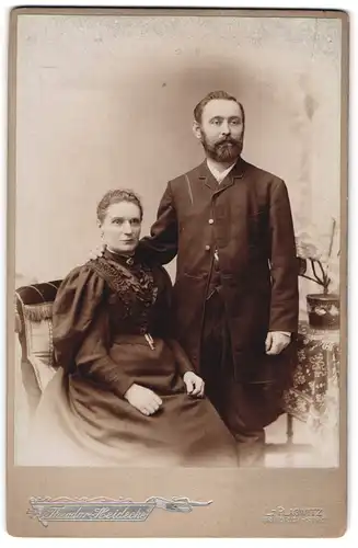Fotografie Theodor Heidecke, Leipzig-Plagwitz, Ehepaar in schwarzer Kleidung im Portrait