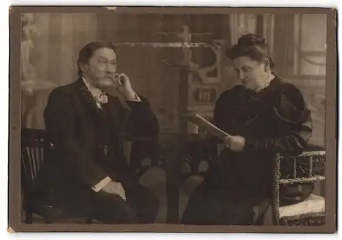 Fotografie Alfred Schmidt, Lindenau, Dame im Kleid liest eine Lektüre, Mann sitzt nachdenklich in einem Stuhl
