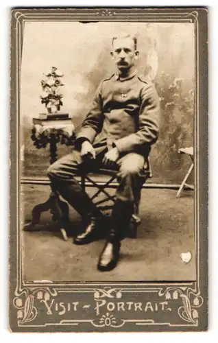 Fotografie Visit-Portrait, unbekannter Ort, Soldat sitzt auf einem Stuhl