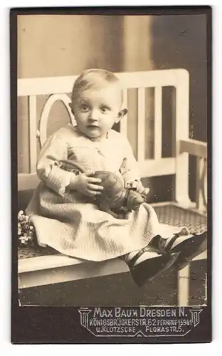 Fotografie Max Baum, Dresden, Kleinkind mit Katzenpuppe sitzt auf einer Bank