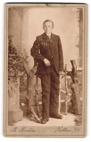 Fotografie B. Boden, Zittau, Junger Bursche in Anzug lehnt an einem Holzgatter