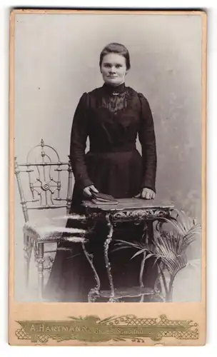 Fotografie A. Hartmann, Gross-Schönau i. S., Portrait hübsche Dame mit Buch am Tisch stehend