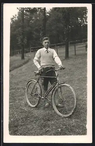 Foto-AK Junger Mann mit Fahrrad auf einer Wiese