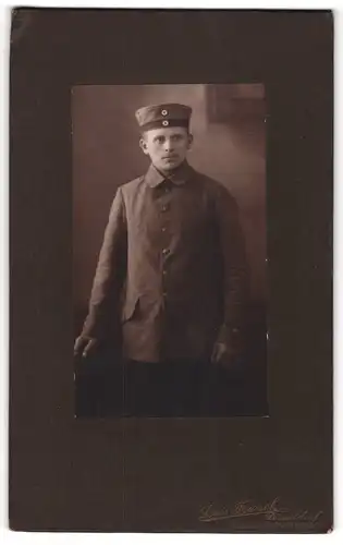 Fotografie Louis Franck, Düsseldorf, junger Soldat in Feldgrau Uniform mit Krätzchen