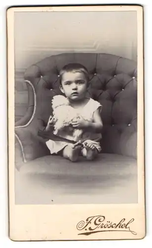 Fotografie F. Gröschel, Rumburg, junges Mädchen Mariechen Klemmer auf einem Sessel mit Spielzeug Schaf