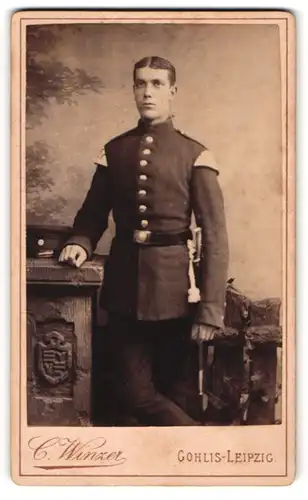Fotografie C. Winzer, Leipzig-Gohlis, Portrait Soldat in Uniform an Sockel gelehnt