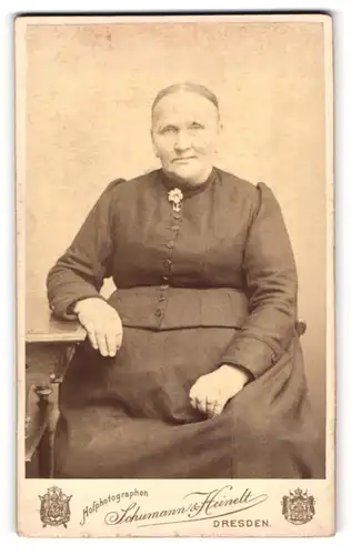 Fotografie Schumann & Heinelt, Dresden-A, Portrait ältere Dame in schlichter Kleidung am Tisch sitzend