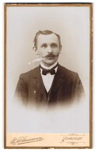 Fotografie R. Schumann, Jöhstadt, Portrait junger Herr im Anzug mit Fliege und Zwirbelbart