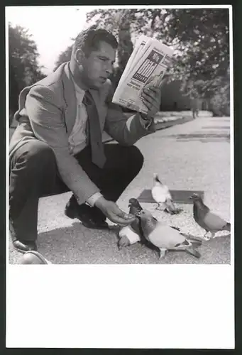 Fotografie Berliner mit BILD-Zeitung füttert Tauben im Park