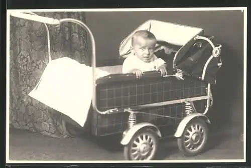 Fotografie Kind schaut verängstigt aus einem Kinderwagen
