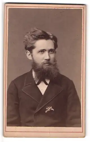 Fotografie Louis Hoyer, Hannover, Portrait vollbärrtiger Herr mit Abzeichen am Jacket