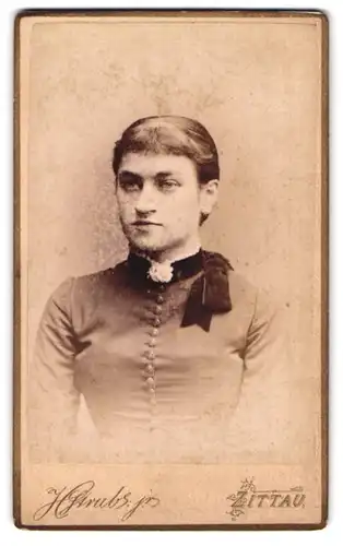 Fotografie H. Strube jr., Zittau, Portrait Frau mit schwarzer Schleife am Kleid