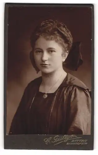 Fotografie C. Güttges, Zittau, Portrait junge Dame mit Haarschleife und Medaillon