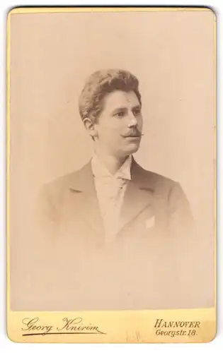 Fotografie Georg Knirim, Hannover, Portrait junger Herr im Anzug mit Krawatte und Zwirbelbart