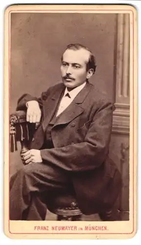 Fotografie Franz Neumayer, München, Portrait modisch gekleideter Herr sitzt auf einem Stuhl