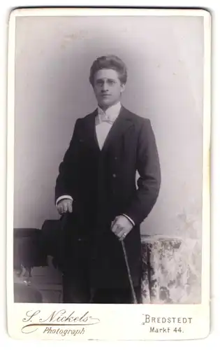 Fotografie S. Nickels, Bredstedt, Portrait junger Herr in eleganter Kleidung mit Hut und Stock