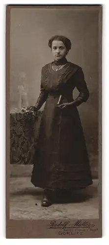 Fotografie Rudolf Müller, Görlitz, Portrait junge Dame im schwarzen Kleid mit Buch