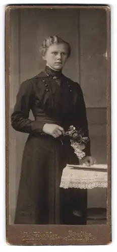 Fotografie Ad. Winkler, Görlitz, Portrait junge Dame im schwarzen Kleid mit Blumen