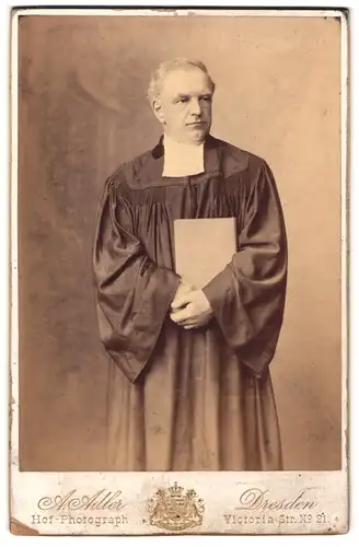 Fotografie A. Adler, Dresden, Portrait Geistlicher in langer Robe mit Bibel in Händen