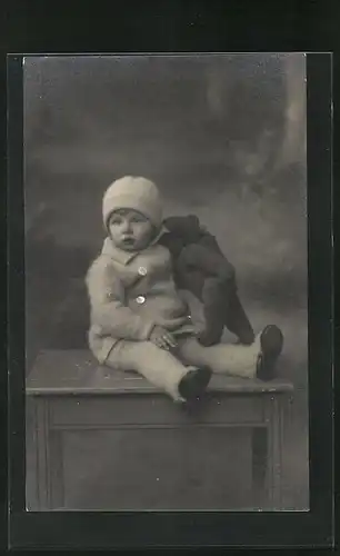 Foto-AK Kleinkind in winterlicher Kleidung mit Mütze und Teddy