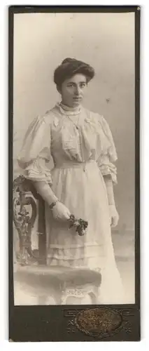 Fotografie E. Schuffert, Borna, Portrait bürgerliche Dame mit Blumen an Stuhl gelehnt