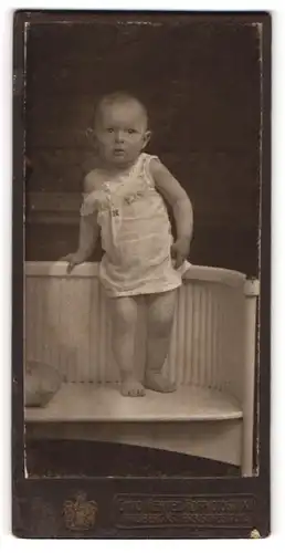 Fotografie Otto Hertel, Freiberg i / S., Portrait niedliches Kleinkind im weissen Hemd auf Bank stehend