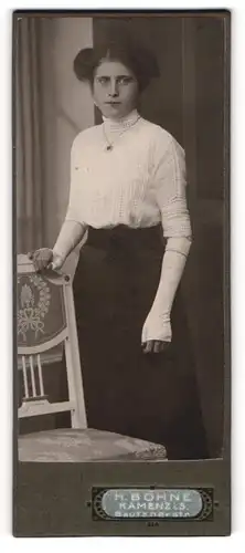 Fotografie H. Bohne, Kamenz i. S., Portrait junge Dame in weisser Bluse an Stuhl gelehnt