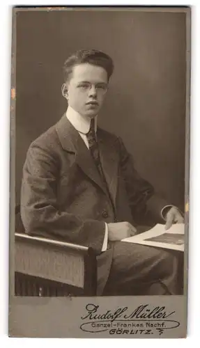 Fotografie Rudolf Müller, Görlitz, Portrait sitzender Mann im eleganten Anzug mit Zeitung