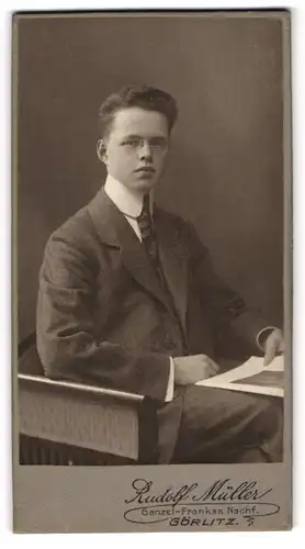 Fotografie Rudolf Müller, Görlitz, Portrait sitzender Mann im eleganten Anzug mit Zeitung