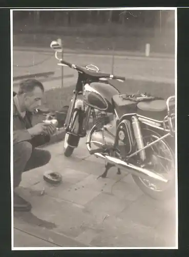 Fotografie Motorrad, Fahrer führt Reparatur am Krad aus