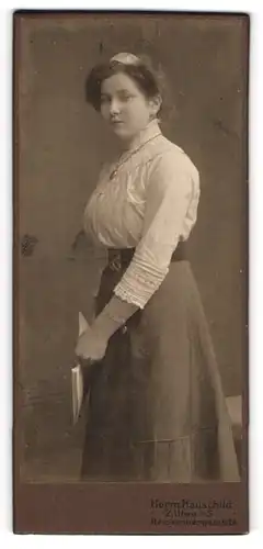 Fotografie Herm. Hauschild, Zittau i / S., Portrait junge Dame in weisser Bluse mit Medaillon und Buch