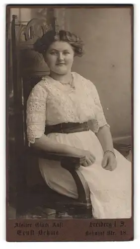 Fotografie Ernst Oehme, Freiberg i. S., Portrait junge Dame in heller Kleidung auf Stuhl sitzend