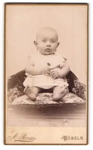 Fotografie A. Pause, Döbeln, Portrait sitzendes Baby im weissen Hemd mit nackigen Füssen