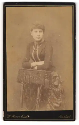 Fotografie W. Herm. Eicke, Einbeck, junge Frau Henny Hoffschmidt lehnt an einer Stuhllehne, 1889