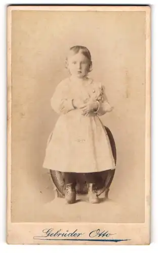 Fotografie Gebrüder Otto, Oranienburg, junges Mädchen Grete Syring im hellen Kleid mit Puppe im Arm