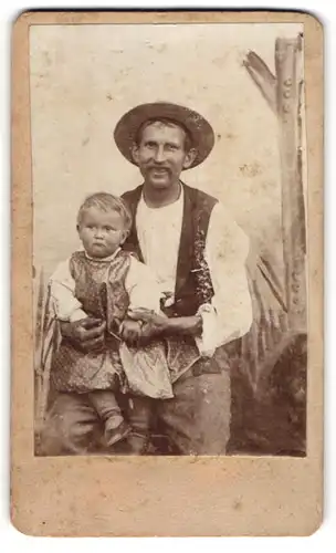 Fotografie unbekannter Fotograf und Ort, Herr Heinrich Lasse mit seinem Sohn Alfred Lasse auf dem Schoss