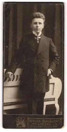 Fotografie Atelier Blankhorn, Cassel, Portrait charmanter junger Mann mit Krawatte im Mantel