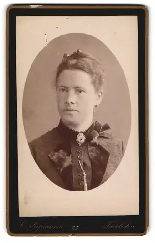 Fotografie O. Siepmann, Iserlohn, Portrait schöne Frau mit Dutt und Brosche am Blusenkragen
