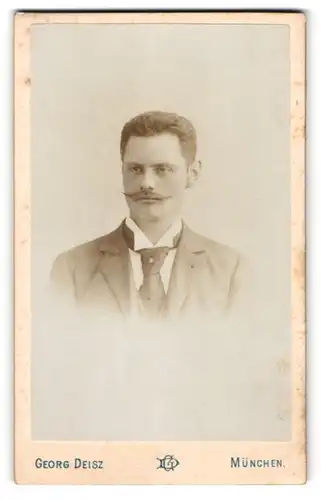 Fotografie Georg Deisz, München, Portrait junger Herr im Anzug mit Krawatte und Zwirbelbart